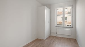 Inflyttningsklar lägenhet med ljusrum, vit garderob och fönster mot innergård