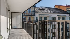 Inflyttningsklar lägenhet med stor balkong och utsikt mot moderna flerbostadshus