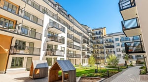 Lägenheter med balkonger och grön innergård i bostadsområde