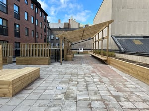 Innergård med platsbyggda blomlådor och pergola