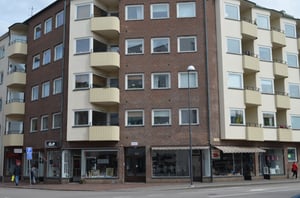 Flerfamiljshus med butikslokaler på bottenvåningen och balkonger på byggnadens framsida