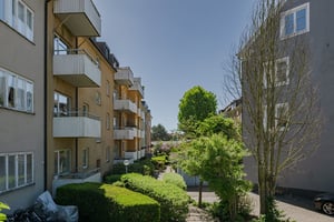 Flerfamiljshus med balkonger och grön innergård i bostadsområde