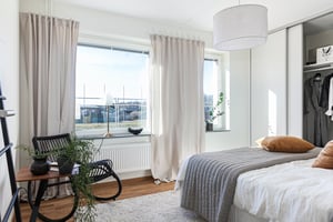 Interiör bild, sovrum med säng och läshörna i fåtölj