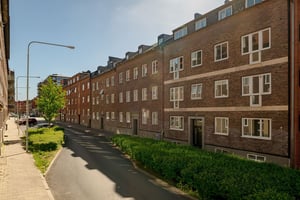 Flerbostadshus i tegel med lokalgata framför huset