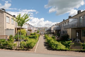 Flerbostadshus i radhuskänsla med grönska mellan bostadshusen