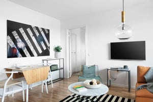 Vardagsrum med mindre matplats, tv och soffa