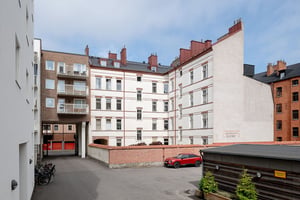 Flerbostadshus i ljus puts som omringar husets innergård