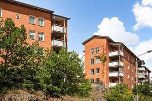 Två flerbostadshus i tegel, med balkonger mot grönområde