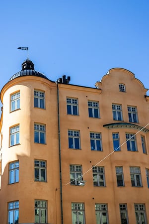 Äldre flerbostadshus med torn och runda hörn i detalj