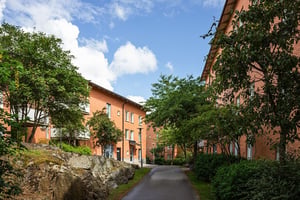 Flerbostadshus i tegel med grönska kring husen