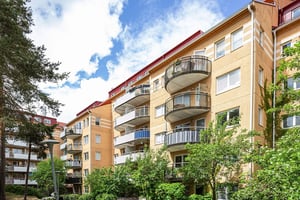 Flerbostadhus i olika nivåer med balkonger och grönska kring husen