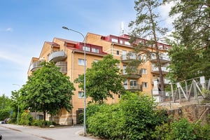 Flerbostadhus i olika nivåer med grönska kring husen