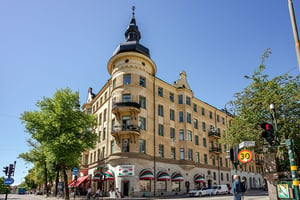 Äldre flerbostadshus med torn och burspråk, med lokaler i entreplan