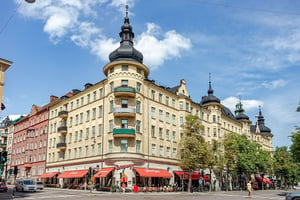 Äldre flerbostadshus med torn och burspråk, med lokaler i entreplan