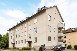 Flerbostadshus i ljus puts längs lokalgata