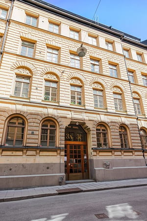 Äldre flerbostadshus i ljust tegel med murade detaljer