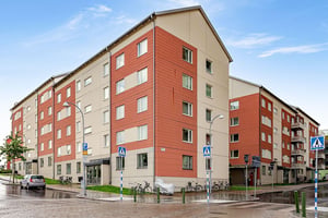 Flerbostadshus i puts och tegel längs lokalgata