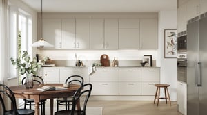Lägenhet med ljus köksmiljö, matbord och moderna vita köksskåp