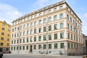 Äldre flerbostadshus med ljus puts och fina fasaddetaljer
