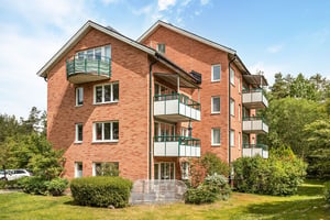 Flerbostadshus i tegel med stora balkonger mot grönområde