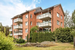 Flerbostadshus i tegel med stora balkonger mot grönområde