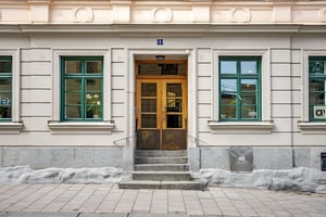 Entreport till äldre flerbostadshus med ljus puts och fina fasaddetaljer