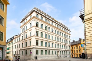 Äldre flerbostadshus med ljus puts och fina fasaddetaljer
