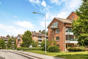 Flerbostadshus i tegel med stora balkonger mot grönområde
