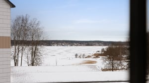 Snötäckt tomt rum med utsikt över frusen sjö och vinterlandskap