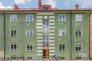 Hyresrättsfastighet med fina detaljer i grön fasad