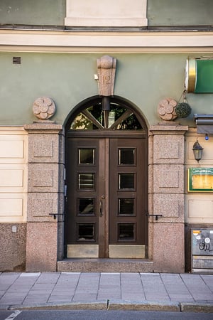 Entreport i äldre hyresrättsfastighet med fina detaljer i fasad