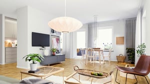 Rum i ljus öppen planlösning med vardagsrum och matplats, vita väggar och trägolv