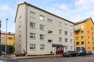 Hyresrättsfastighet mot lokalgata, med parkerade bilar