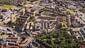 Flygvy över ett stadsområde med bostadshus, kontor, vägar och en stor grön park