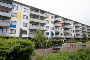 Hyresrättsfastighet med balkonger mot innergård med lekplats