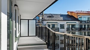 Inflyttningsklar lägenhet med balkong och utsikt mot moderna flerbostadshus