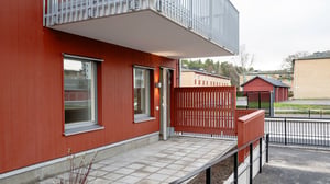 Röd fasad, balkong och uteplats
