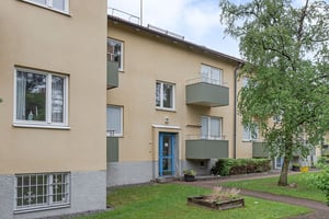Hyresrättsfastighet med balkonger och gräsmattor framför huset