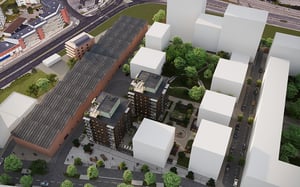 Flygvy över ett bostadsområde med två flerbostadshus, grönska, gångvägar och omgivande stadsbebyggelse