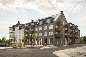 Flerbostadshus med balkonger och nyanlagd gård