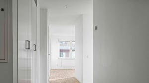 Inflyttningsklar lägenhet med ljusa väggar, trägolv och garderober i hallen