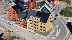 Flera flerbostadshus i nybyggt område med gator, trottoarer och pågående byggarbete