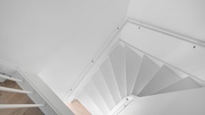 Inflyttningsklart trapphus med vit spiraltrappa och ljusa väggar