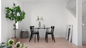 Inflyttningsklar lägenhet med matplats, svart bord och stolar samt ljus interiör