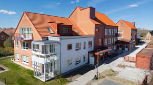 Inflyttningsklar lägenhet i bostadsområde med moderna flerfamiljshus och röda tegelfasader