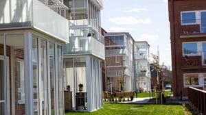 Inflyttningsklar lägenhet i modernt bostadshus med glasade balkonger och grön innergård