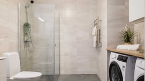 Modernt badrum med dusch, toalett och tvättmaskin