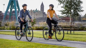 Två personer cyklar på en parkstig I Norrköping