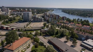 Flygvy över ett bostadsområde vid Umeälven, med flera flerfamiljshus, vägar och grönområden
