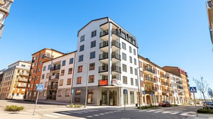 Nyproducerade lägenheter i flerbostadshus med balkonger vid gata i bostadsområde